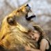 A small girl with a lion hugging