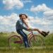 Young couple riding a bicycle while kissing
