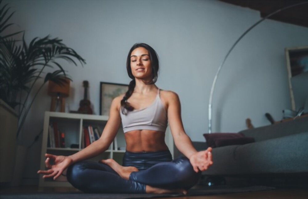 A woman meditating on a yoga mat