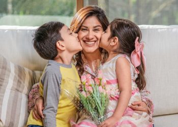 Two children giving their mother affectionate kisses on Mother's Day