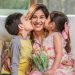Two children giving their mother affectionate kisses on Mother's Day